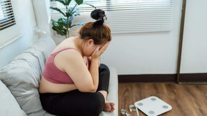 une femme est triste à cause de sa prise de poids